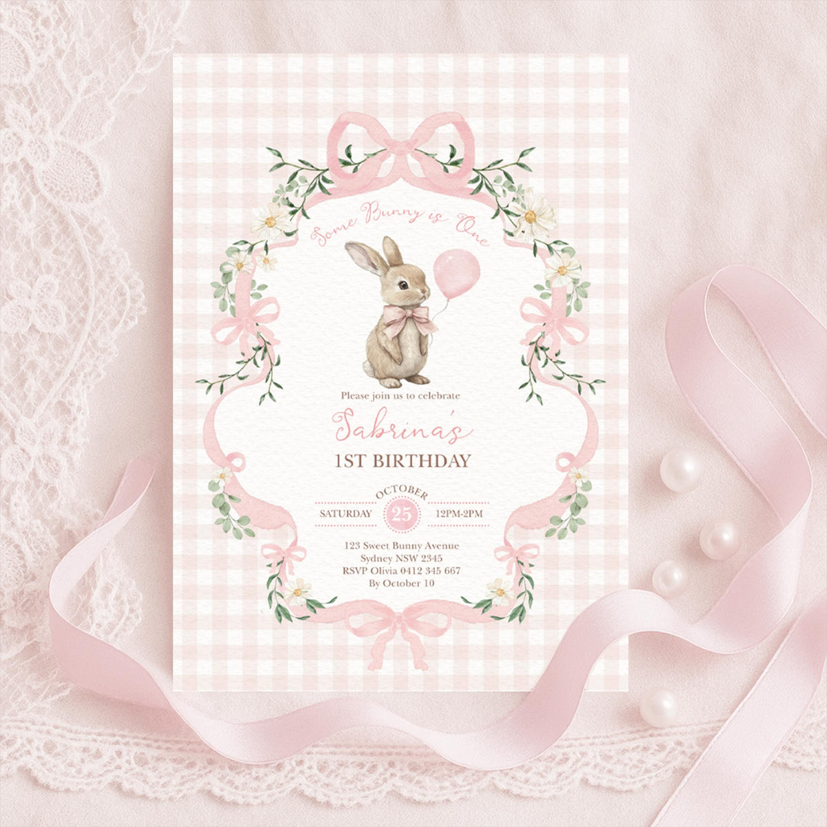 Pink gingham Some Bunny is One invitation with a rabbit holding a pink balloon, bows and daisies