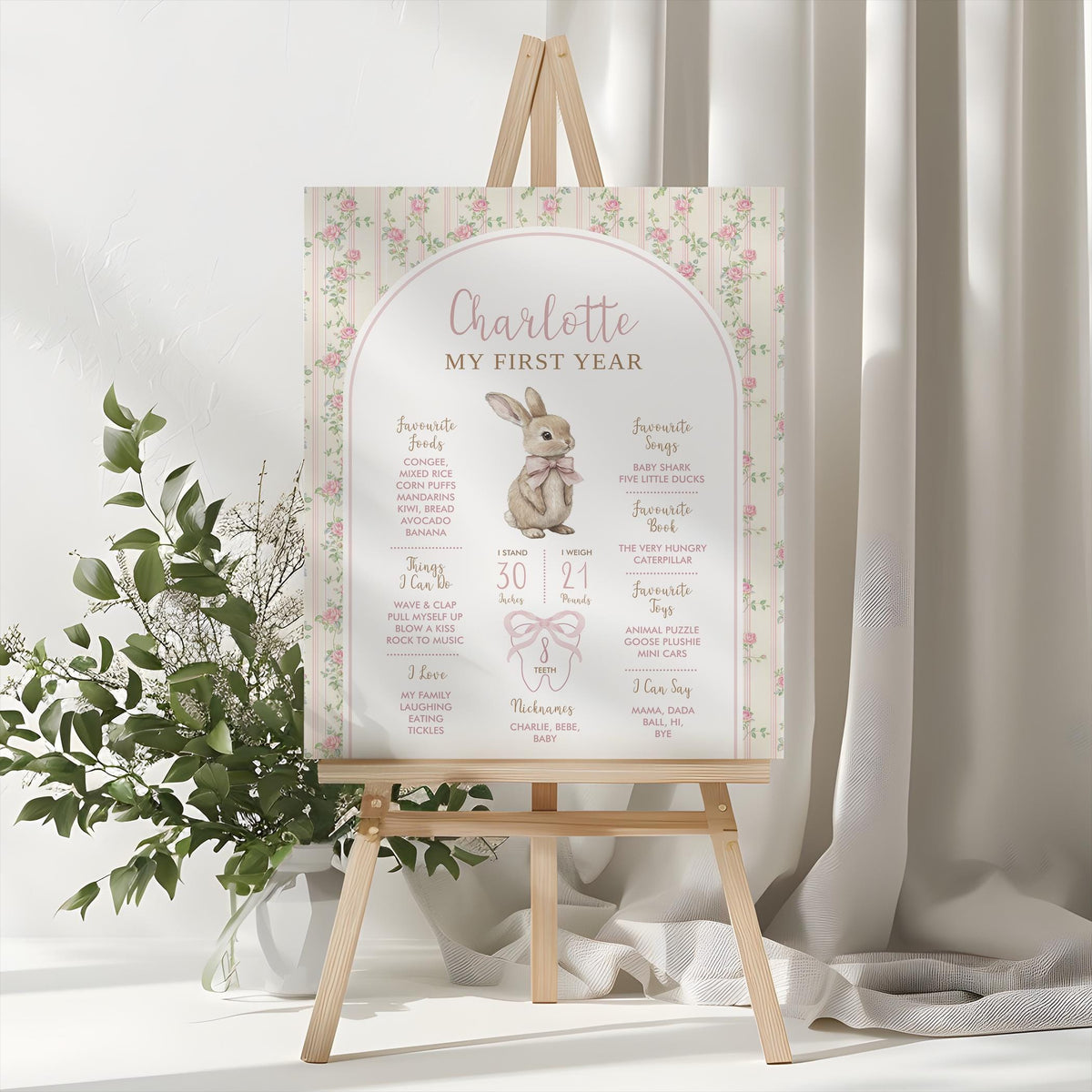MY FIRST YEAR milestone board on a wooden easel, styled with eucalyptus and white flowers