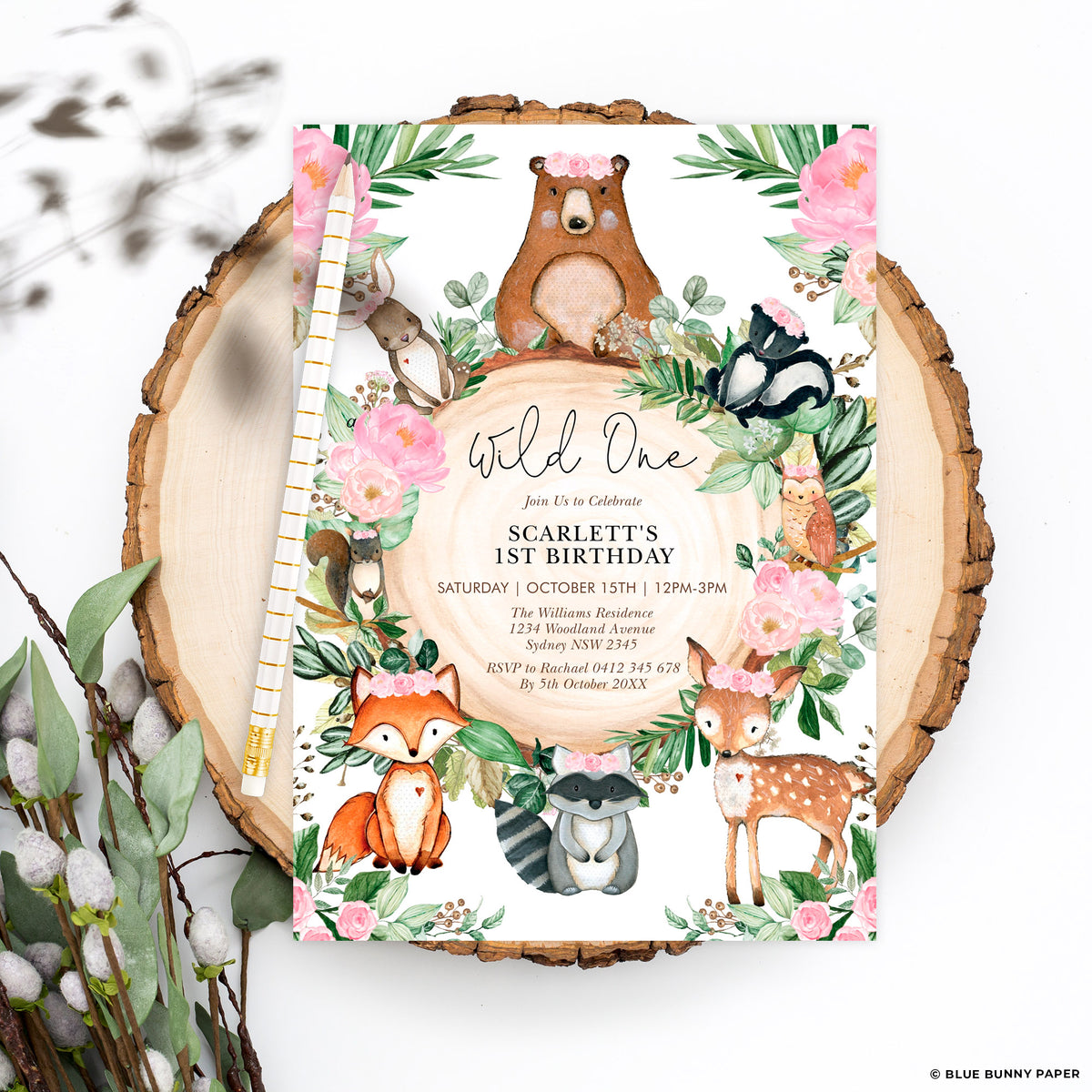 Woodland Wild One first birthday invitation for Scarlett on a big wood slice with dried foliage
